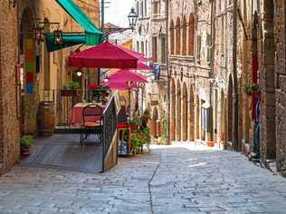 The charming narrow streets of Volterra in Tuscany and below right, the medieval palace Palazzo Dei Priori. Picture: baratroli