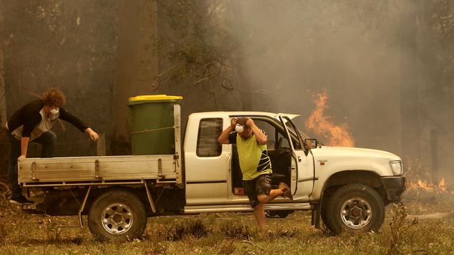 Jamie Fato prepares to stop an out of control fire entering Owen Whalan’s property at Koorainghat, near Taree, on Tuesday. Picture: AAP/Darren Pateman