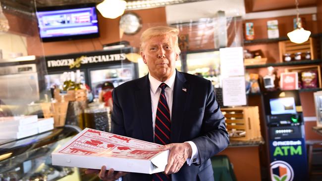 US President Donald Trump grabs a pizza while on the campaign trail in Old Forge, Pennsylvania, on Friday AEST. Picture: AFP