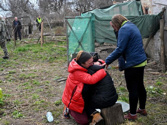 Other woman comfort the grieving wife. Picture: Sergei Supinsky /AFP