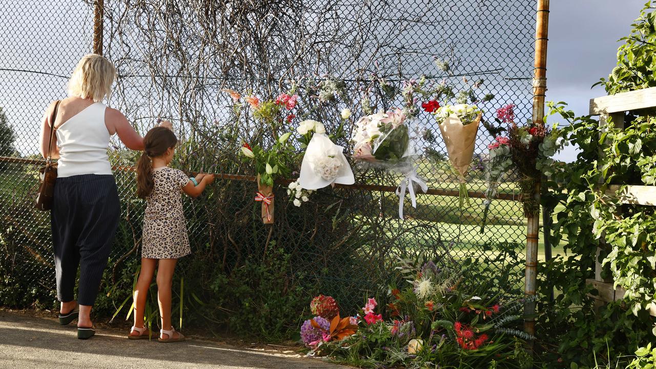 Floral tributes have been left on a pathway leading to Little Bay beach. Picture: Richard Dobson