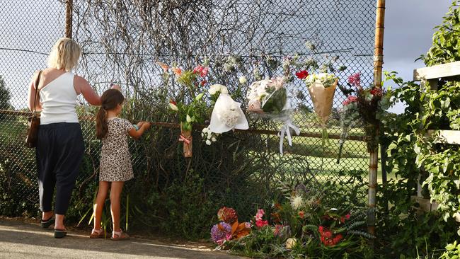 Floral tributes have been left on a pathway leading to Little Bay beach. Picture: Richard Dobson