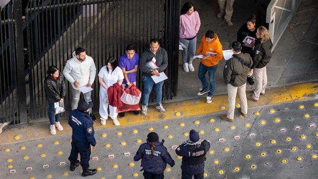 Mexican immigration officials and police receive deportees after they were sent back into Mexico. Picture: Getty Images