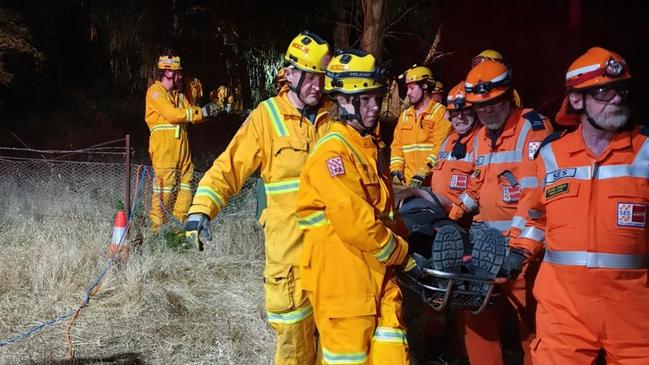 Kinglake SES and firefighters carry a parachuter to an ambulance moments after he was freed from a tree. Picture: Kinglake SES