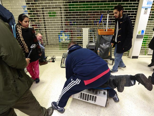 Customers fall to the floor as they grapple for an LED television during a Black Friday discount sale at an Asda supermarket, operated by Wal-Mart Stores Inc., in the Wembley district of London. Picture: Simon Dawson/Bloomberg via Getty Images