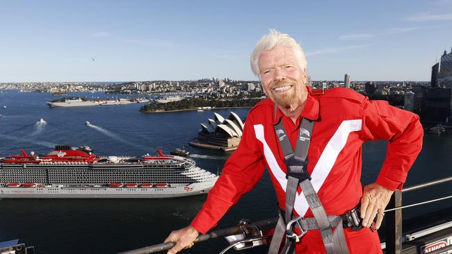 We are not as financially strong as we were, Sir Richard Branson says. He is seen here on the Sydney Harbour Bridge with the first Virgin Voyages cruise ship, the Resilient Lady arriving in Sydney this week. Picture: Jonathan Ng