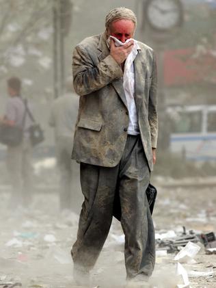 Edward Fine covers his mouth as he walks through the debris after the collapse of one of the World Trade Center Towers in New York. Fine was on the 78th floor of 1 World Trade Center when it was hit. Picture: Stan Honda