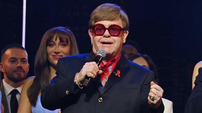 LONDON, ENGLAND - DECEMBER 01: (L to R) Shaina Taub, Sir Elton John and David Furnish speak on stage at "The Devil Wears Prada Musical" charity gala night in support of the Elton John Aids Foundation at The Dominion Theatre on December 1, 2024 in London, England. (Photo by Dave Benett/Getty Images for The Devil Wears Prada Musical)