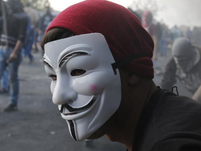 A protester wearing a mask of the anonymous movement takes part in confrontations between Palestinian demonstrators and Israeli security forces at the entrance of the Palestinian town of al-Bireh, on the outskirts of Ramallah in the Israeli-occupied West Bank, on November 11, 2015. The trademark mask is a stylised depiction of Guy Fawkes, the best-known member of the Gunpowder Plot, an attempt to blow up the House of Lords in London in 1605. AFP PHOTO / ABBAS MOMANI