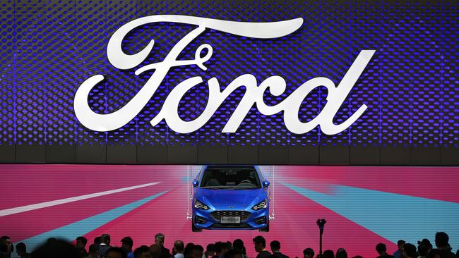 Visitors and journalists crowd near a Ford Focus on display at the Ford exhibit during the media day for the China Auto Show in Beijing. (AP Photo/Andy Wong)