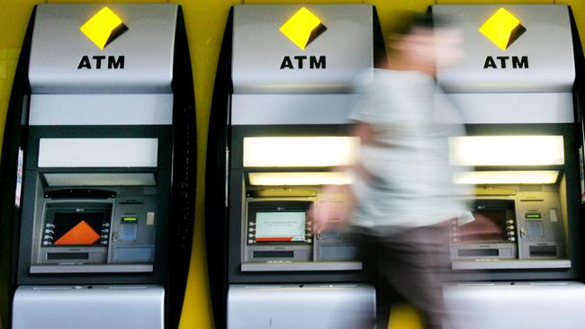 A pedestrian walks past Automated Teller Machines (ATM's) of the Commonwealth Bank of Australia in Sydney, Australia, on Tuesday, Feb. 12, 2008. Photographer: Ian Waldie/Bloomberg News