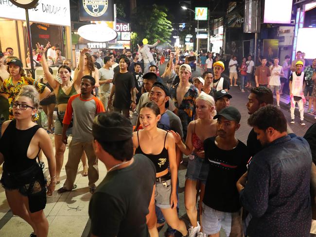 A large crowd gathers to watch as young Australians are involved in a fight in Kuta’s nightclub district. Picture: Liam Kidston