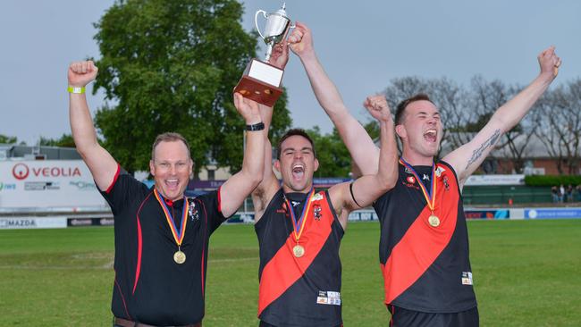 Tea Tree Gully coach Justin Maschotta lifts the division two premiership trophy with co-captains Chad Schoenmakers and Blake Penney last year. Maschotta has left the Adelaide Footy League club. Picture: Brenton Edwards