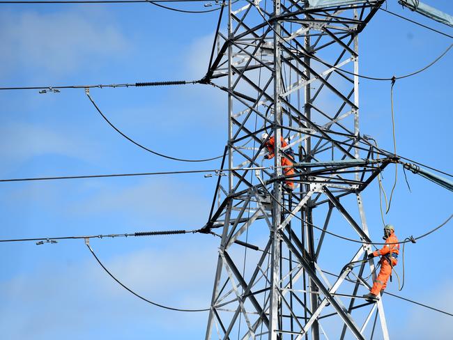 **FILE** A July 20, 2015 file photo of workers seen on a high tension electricity pylon in suburban Sydney. The energy market operator warns NSW and South Australia could face power shortages as temperatures soar in coming days, Friday, Feb. 10, 2017. (AAP Image/Mick Tsikas) NO ARCHIVING