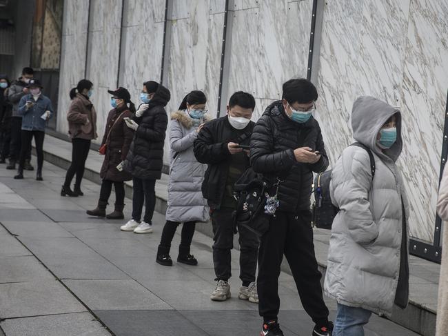 WUHAN, CHINA - MARCH 30: (CHINA OUT) People wearing face masks line up to enter Wuhan international plaza on March 30, 2020 in Hubei Province, China. Wuhan, the central Chinese city where the coronavirus (COVID-19) first emerged last year, will lift the lockdown on April 8, local media reported. (Photo by Getty Images)