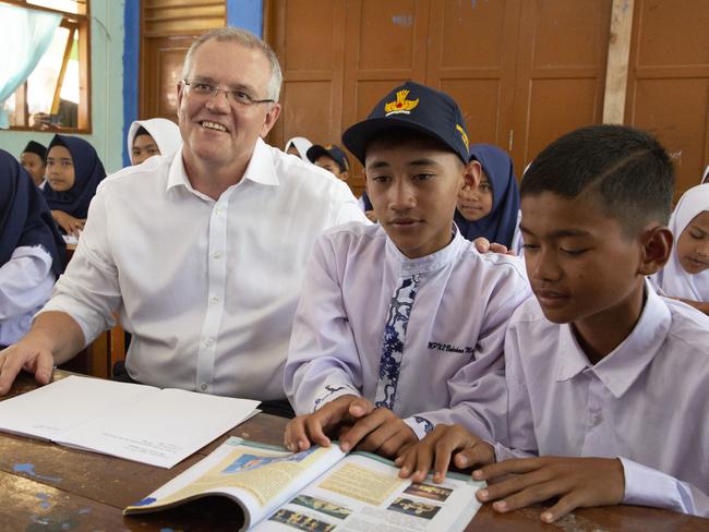 Scott Morrison rolling up his sleeves on a state visit to Indonesia. Picture: Getty Images