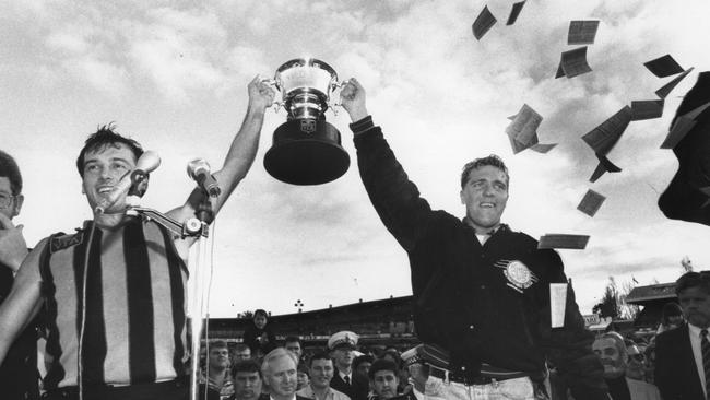 Trevor Barker and Anthony Allen lift the 1992 premiership coach.