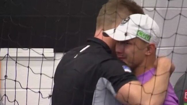 Collingwood runner Alex Woodward and Nathan Buckley embrace after the 2018 Grand Final