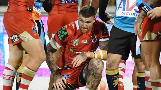 Josh Dugan of the Dragons (centre) kneels on the pitch after a heavy tackle.