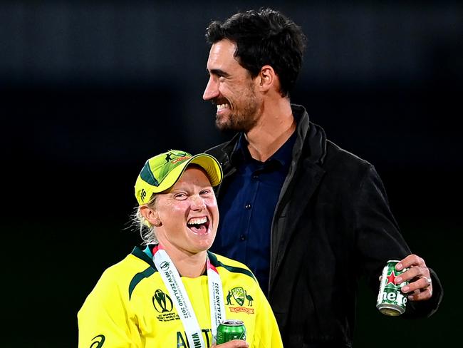 CHRISTCHURCH, NEW ZEALAND - APRIL 03: Alyssa Healy of Australia shares a moment with husband Mitchell Starc in the pitch after Australia won the 2022 ICC Women's Cricket World Cup Final match between Australia and England at Hagley Oval on April 03, 2022 in Christchurch, New Zealand. (Photo by Hannah Peters/Getty Images)