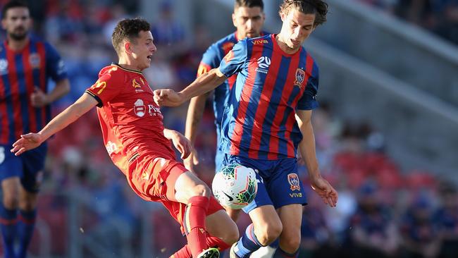 Adelaide’s Louis D'Arrigo (left) and Newcastle’s Matthew Ridenton compete for the ball on Saturday. Picture: Getty Images