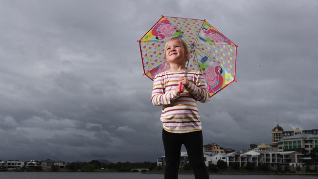 Five year old Hazel Taylor from Carrara gets ready to leave the beach at Emerald Lakes as rain approaches. Picture Glenn Hampson