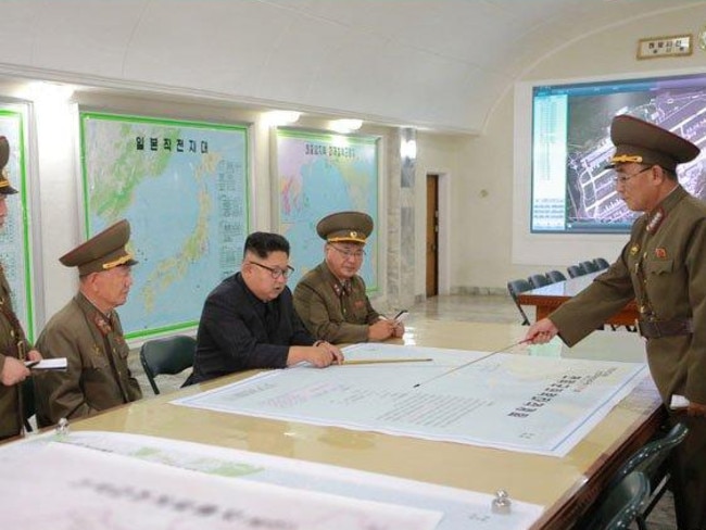 Kim Jong-un pictured with plans to launch ballistic missiles towards the US territory of Guam. Picture: KCNA