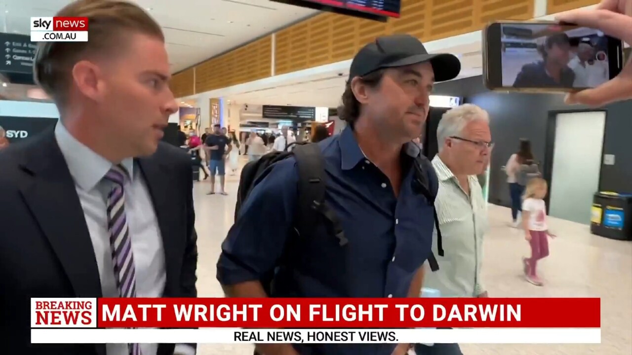 Matt Wright confronted by media at Sydney Airport after arrest warrant issued