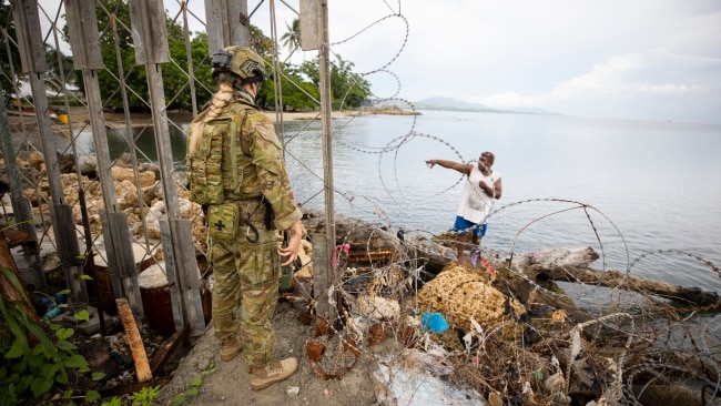 An ADF soldier talks with a local fisherman at Guadalcanal Port on November 28, 2021 in Honiara, Solomon Islands. Australia sent $544 million in development assistance to the island nation between 2019 and 2021 (Photo by CPL Brandon Grey/Australian Department of Defence via Getty Images)