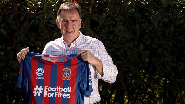 Newcastle Jets CEO Lawrie McKinna with the club shirt featuring the Football for Fires logo.