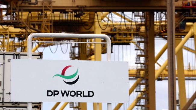 A gantry crane adorned with a logo for ports operator DP World is seen behind company signage at an entrance to the Port Botany compound in Sydney.