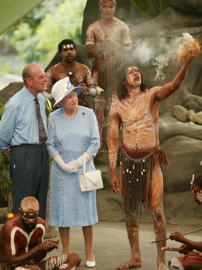 Queen Elizabeth II and her husband Prince Philip watch Tjapukai Aborigines light a ceremonial fire during a cultural performance near Cairns on March 1, 2002. The British monarch was in Australia on the final leg of her golden jubilee tour. AFP PHOTO / TORSTEN BLACKWOOD