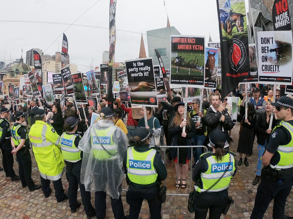 A line of police officers stood in front of the protesters as they held signs and chanted at the passing parade. Picture: Mark Evans/Getty Images