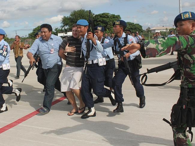 Escorted into questioning ... Matt Lockley is handcuffed and pushed by Indonesian Air Force soldiers into Ngurah Rai airport in Denpasar.