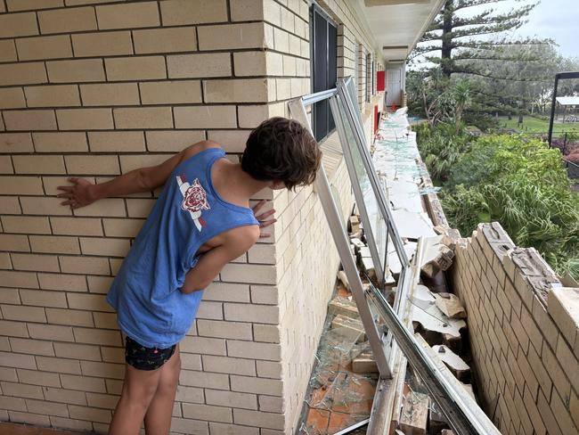 King Tide apartments resident Lincoln, 14, inspecting the damage caused by Cyclone Alfred’s Friday night blast to the Gold Coast.