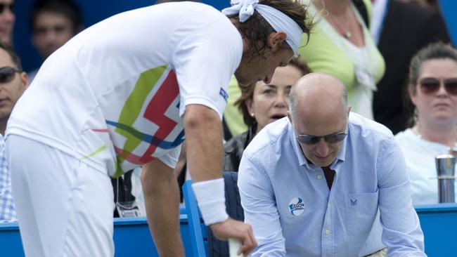 David Nalbandian (L) speaks to injured line judge Andrew McDougall