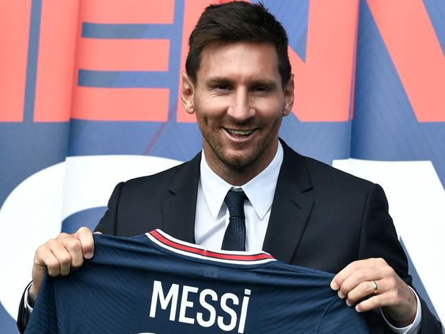 Argentinian football player Lionel Messi poses as he holds-up his number 30 shirt during a press conference at the French football club Paris Saint-Germain's (PSG) Parc des Princes stadium in Paris on August 11, 2021. - The 34-year-old superstar signed a two-year deal with PSG on August 10, 2021, with the option of an additional year, he will wear the number 30 in Paris, the number he had when he began his professional career at Spain's Barca football club. (Photo by STEPHANE DE SAKUTIN / AFP)