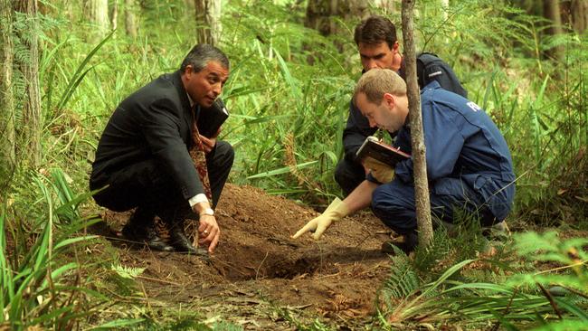 Homicide Detective Charlie Bezzine with forensic officers at double gravesite in Cambarville.