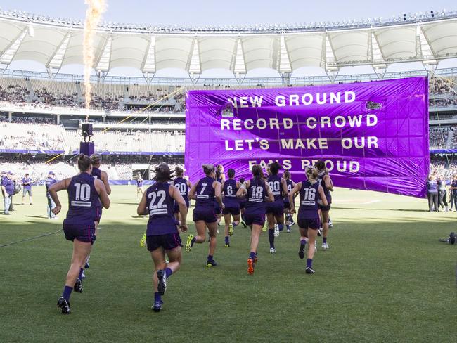 The Dockers run onto the field during the Round 2 AFLW match between the Fremantle Dockers and the Collingwood Magpies at Optus Stadium in Perth, Saturday, February 10, 2018. (AAP Image/Tony McDonough) NO ARCHIVING, EDITORIAL USE ONLY