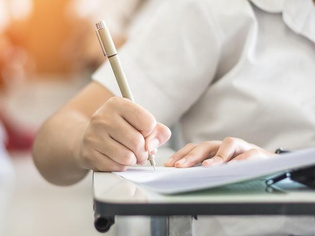 Exam with school student having a educational test, thinking hard, writing answer in classroom for university education admission and world literacy day concept