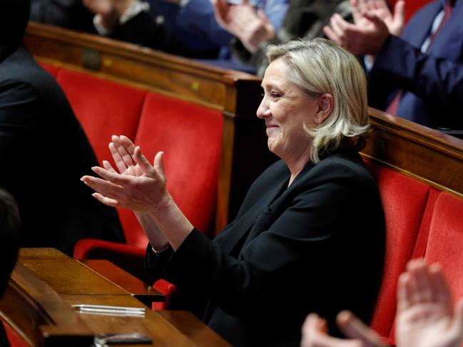 President of Rassemblement National parliamentary group Marine Le Pen applauds during a session to vote on the special budget draft law at the National Assembly in Paris on December 16, 2024. In the absence of a budget for 2025, the deputies will examine on December 16, 2024 a special bill, intended to guarantee the continuity of the State, by allowing taxes to be raised, credits to be spent on the basis of the previous budget, and authorizing the State and Social Security to borrow. (Photo by GEOFFROY VAN DER HASSELT / AFP)