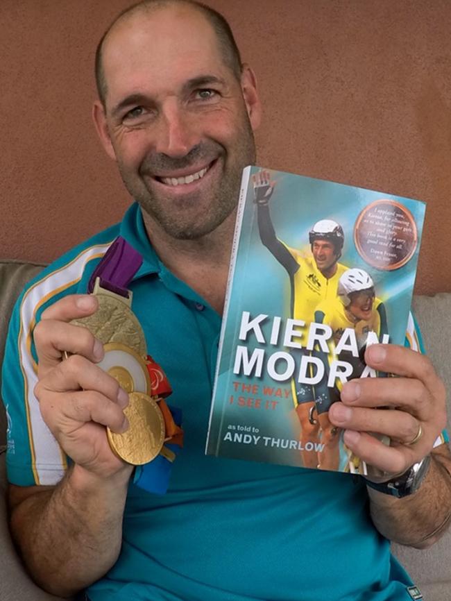 Kieran Modra with his Paralympic medals and the original version of the biography, Kieran Modra: The Way I See It.