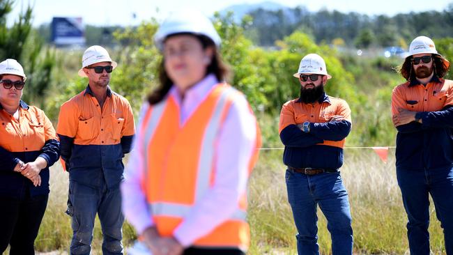 Construction workers pause at the Bells Creek Arterial Rd upgrade site during Queensland Premier Annastacia Palaszczuk’s press conference. Picture: NCA NewsWire / Dan Peled