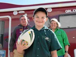 YOUNG CHAMP: Queensland Outback QRL central division operations manager Peter Rafter and Drought Angel Carissa Liddle flank Alex Liddle, 9, who approached the QRL about providing footballs for drought-stricken farmers. Picture: Brooke Duncan