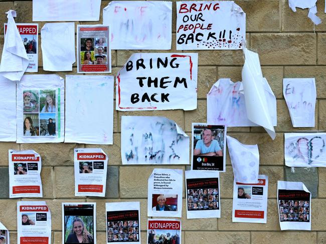 Images of Israeli hostages snatched by the Palestinian militant group Hamas plastered on a wall during a rally outside the Ministry of Defense in Tel Aviv. Picture: AFP