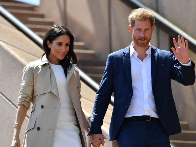 Prince Harry and his wife Meghan walk down the stairs of the Opera House to meet people in Sydney. Picture: Saeed Khan/AFP