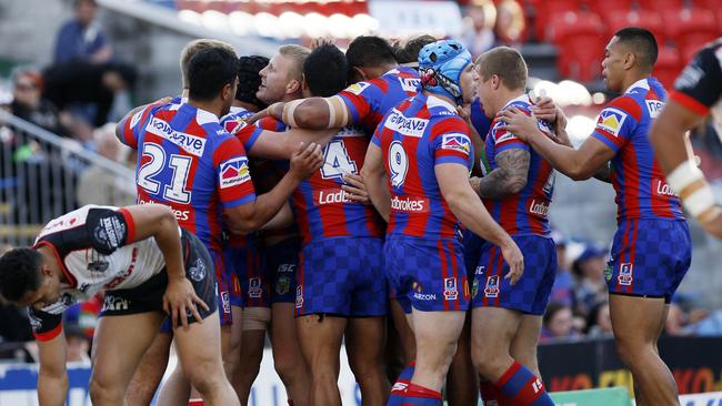 Knights players celebrate the first of two tries to Mitchell Barnett against the Warriors.