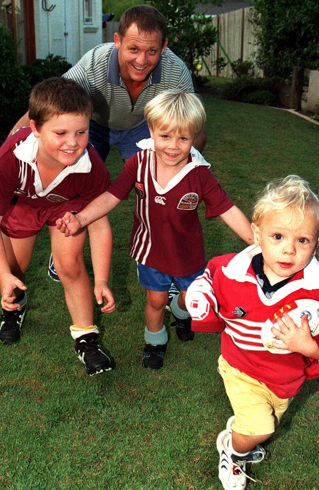 Kevin Walters playing backyard footy with his children Jack, Billy and Jett.