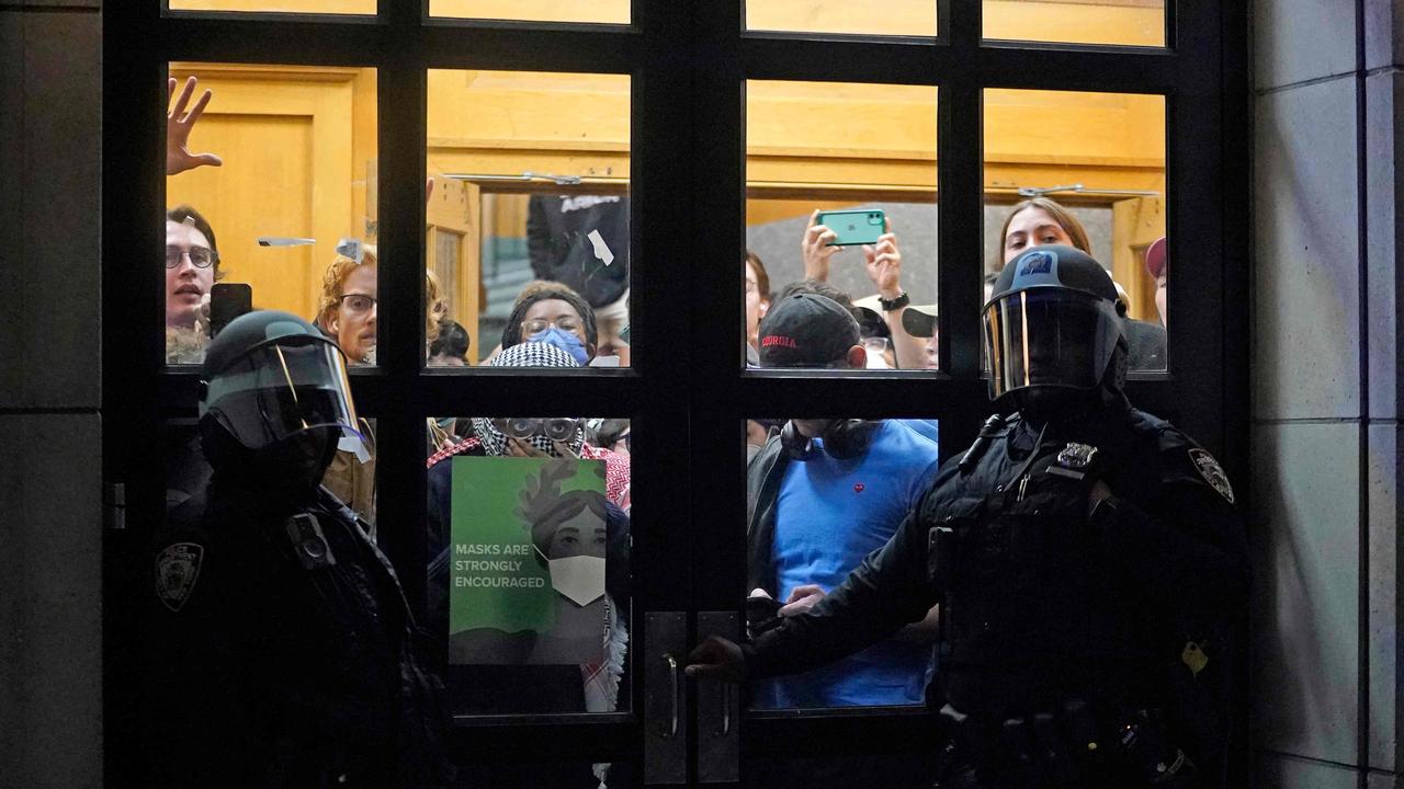 NYPD officers stand next to barricaded students. Picture: TIMOTHY A. CLARY / AFP
