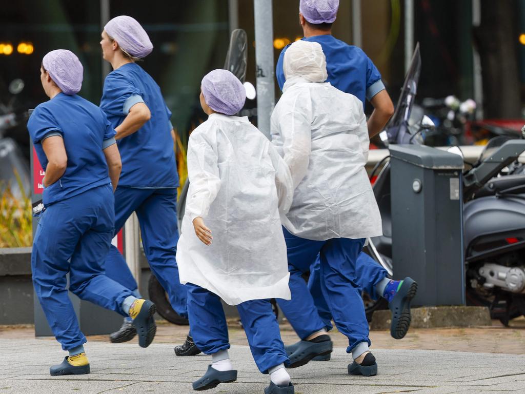Medical staff leave the Erasmus MC hospital that has been cordoned off following reports of a shooting, in Rotterdam. (Photo by BAs Czerwinski / ANP / AFP) / Netherlands OUT